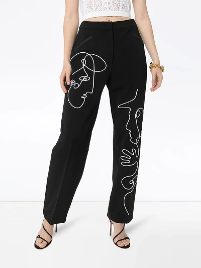 Shop Moschino Face Embroidered Trousers In Black