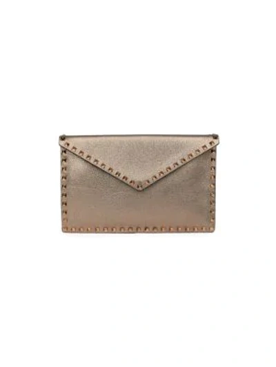 Shop Valentino Garavani Large Rockstud Metallic Leather Clutch In Sasso