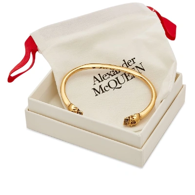 Shop Alexander Mcqueen Twin Skull Bracelet In Gold