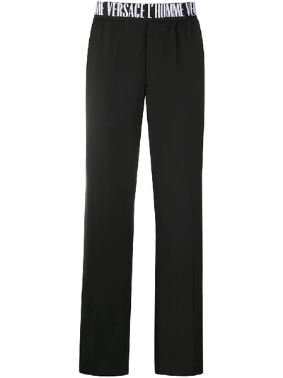 Shop Versace Logo Waistband Straight-leg Trousers In Black