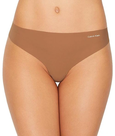 Shop Calvin Klein Invisibles Thong In Bronzed
