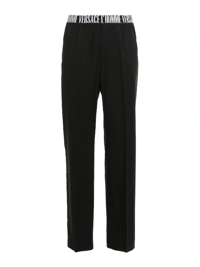 Shop Versace Logo Waistband Trousers In Black