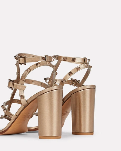Shop Valentino Rockstud Gladiator Heeled Sandals In Gold