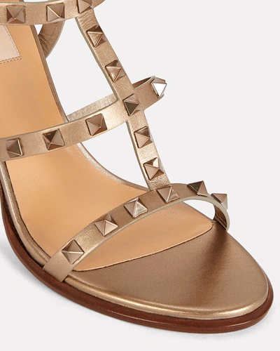 Shop Valentino Rockstud Gladiator Heeled Sandals In Gold