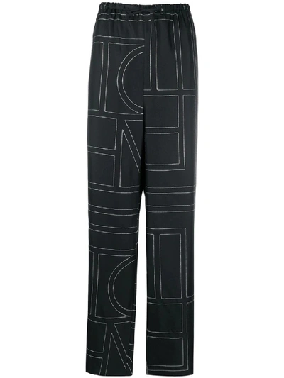 Shop Totême Vizelle Monogram-print Trousers In Black