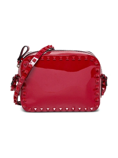 Shop Valentino Small Rockstud Crossbody Bag In Patent Leather In Red