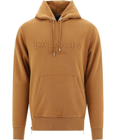 Shop Balmain Logo Embossed Hoodie In Brown