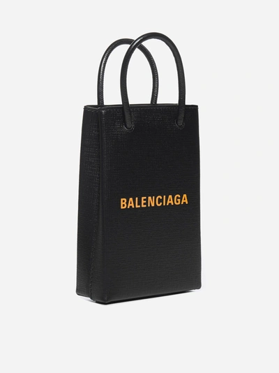 Shop Balenciaga Logo Leather Shopping Phone Holder In Black - Orange