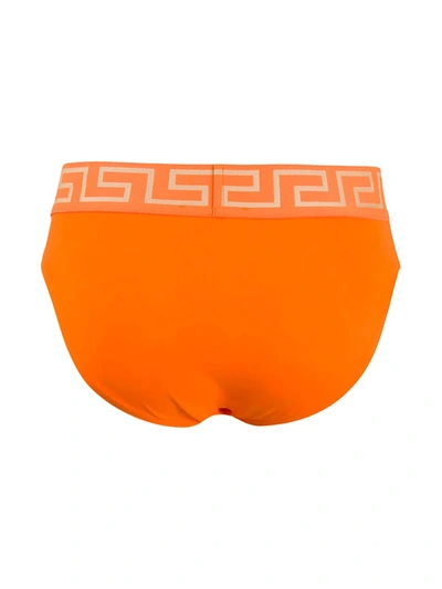Shop Versace Greca Border Swim Briefs In Orange