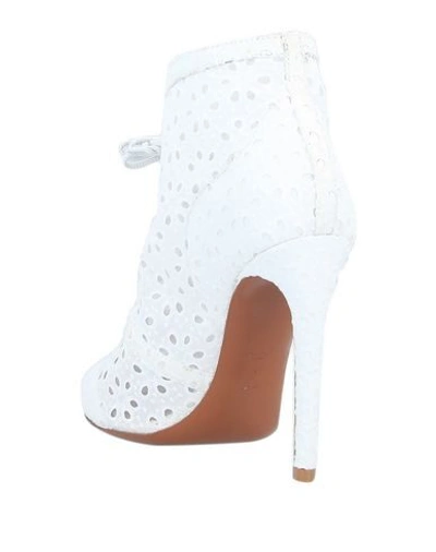 Shop Alaïa Ankle Boots In White