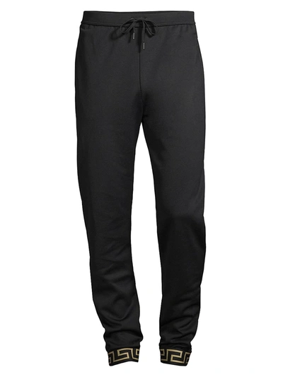 Shop Versace Technical Jersey Pants In Black Gold