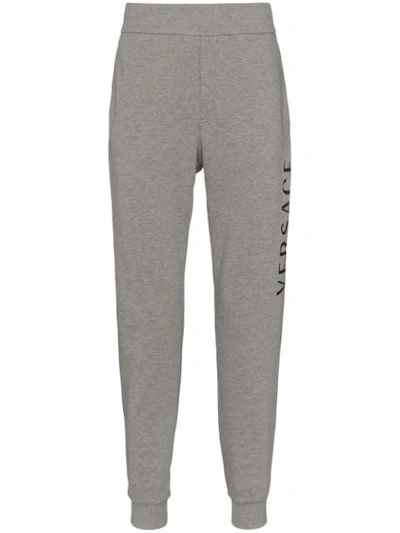 Versace Printed Logo Cotton Jersey Sweatpants In Grigio Chiaro