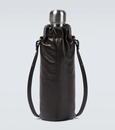 A BLACK LAMBSKIN LEATHER HOT WATER BOTTLE HOLDER WITH GOLD
