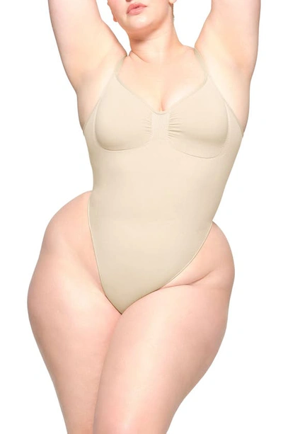 Skims Seamless Sculpt Low Back Thong Bodysuit In Sand