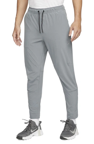 Nike Men's Unlimited Dri-fit Zippered Cuff Versatile Pants In Smoke Grey/ Black/ Smoke Grey