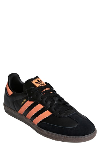 black adidas trainers with orange stripes