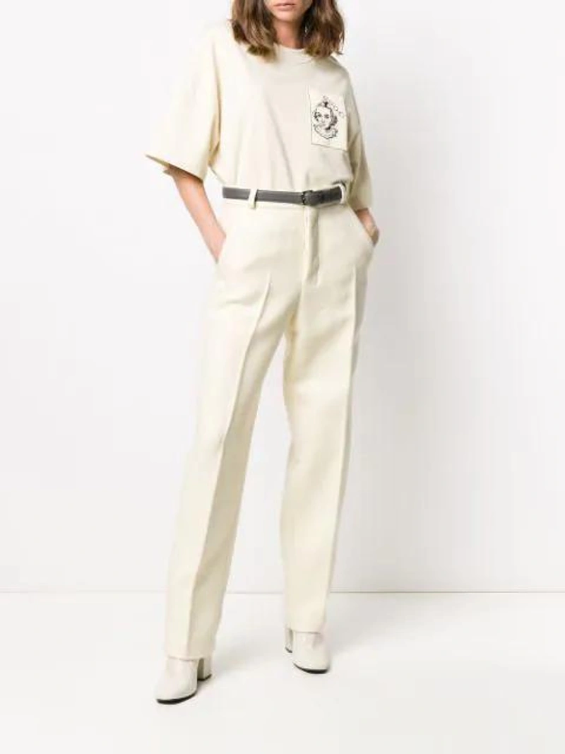 Farfetch's Post | Wearing: Ami Alexandre Mattiussi High-waisted Straight-leg Trousers In Neutrals; Ami Alexandre Mattiussi T-shirt With Face Woven Label In Neutrals; Ami Alexandre Mattiussi Chunky-heel 100mm Ankle Boots In White