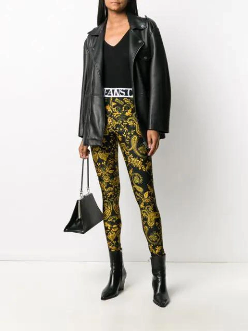 Farfetch's Post | Wearing: Versace Jeans Couture Baroque-print Slim-fit Leggings In Black; Totême Black Savona Tank Top; Ganni Oversized Textured-leather Biker Jacket In Black