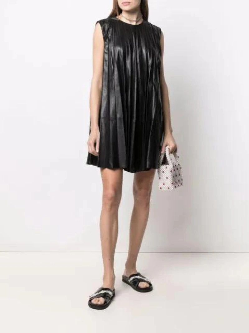 Farfetch's Post | Wearing: Red Valentino Pleated Leather Shift Dress In Black; Shrimps Dolly Faux-pearl And Bead-embellished Bag In Neutrals; Ambush Sterling Silver Heart Charm Necklace