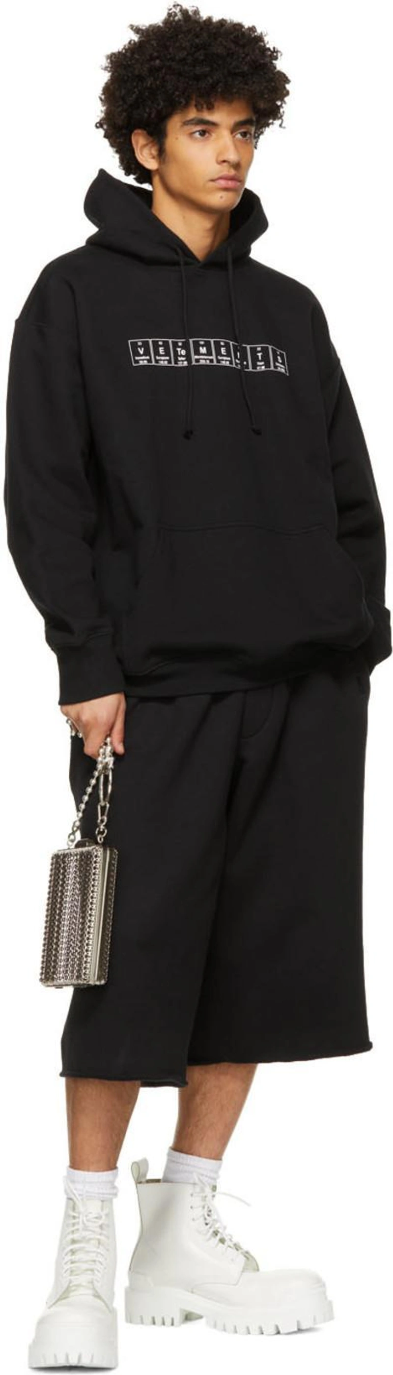 SSENSE's Post | Wearing: Vetements Chemical Logo-print Cotton-blend Hooded Sweatshirt In Black; Balenciaga Black Oversize Bermuda Shorts In 1069 Black/; Martine Ali Silver Captain Side Clutch Bag