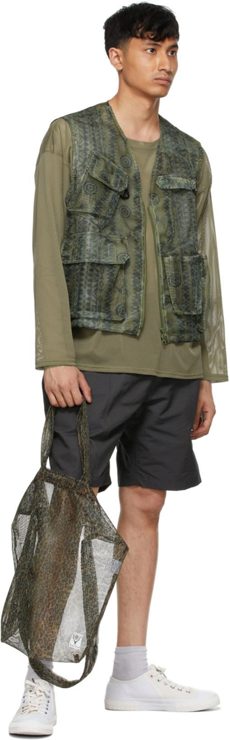 SSENSE's Post | Wearing: South2 West8 Khaki Mesh Sweater In Olive; South2 West8 Khaki Skull & Target Bush Trek Vest In Skulltarget; South2 West8 Grey Belted Center Seam Shorts In Charcoal