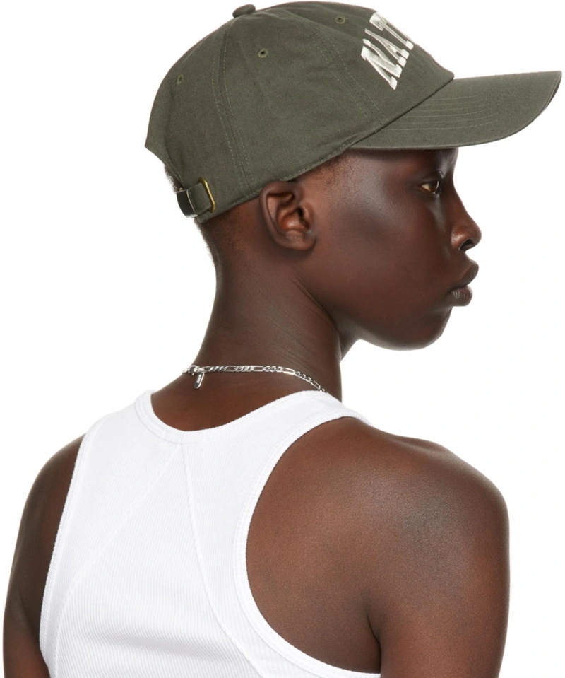 SSENSE's Post | Wearing: Rag & Bone The Essential Scoop Neck Ribbed Tank In White; Museum Of Peace And Quiet Ssense Exclusive Green 'natural' Cap In Forest; Numbering Silver #855 Necklace