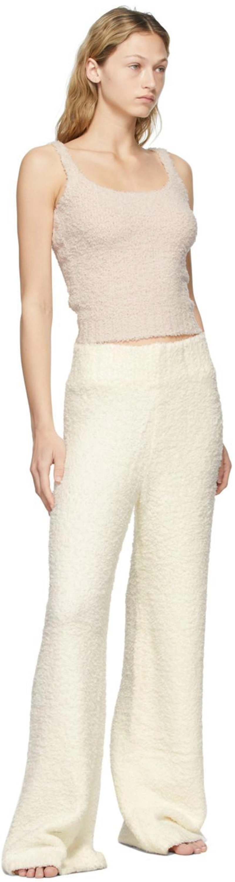 SSENSE's Post | Wearing: Skims Pink Knit Cozy Tank Top In Dusk; Skims Off-white Knit Cozy Lounge Trousers In Ivory