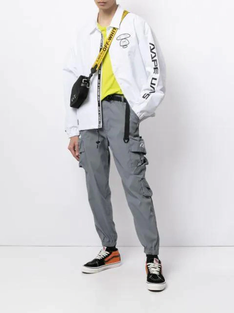 Farfetch's Post | Wearing: Aape By A Bathing Ape Logo-print Shirt Jacket In White; Champion Crew Neck Short Sleeved T In Green; Aape By A Bathing Ape Appliqué-patches Track Pants In Grey