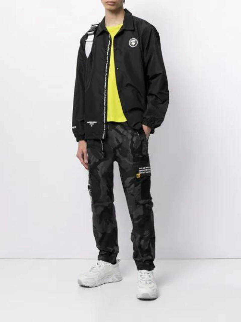 Farfetch's Post | Wearing: Marine Serre Crescent Moon Print-recycled-fibre Face Covering In Black  ; Aape By A Bathing Ape Aape Lightweight Logo Coach Jacket In Black; Champion Crew Neck Short Sleeved T In Green