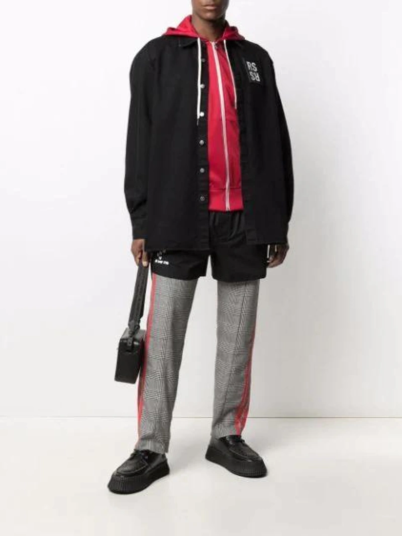 Farfetch's Post | Wearing: Raf Simons Denim Shirt With Logo Patch In Black; Raf Simons Patch-detail Track Shorts In Black; Ami Alexandre Mattiussi Side Stripe Zip-up Hoodie In Red