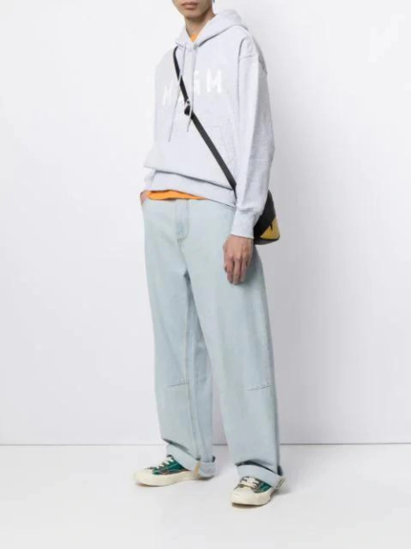 Farfetch's Post | Wearing: Msgm Wide-leg Jeans In Blue; Champion Logo Embroidered Cotton T In Orange; Fendi Black Monster Eyes Leather Camera Bag In Yellow