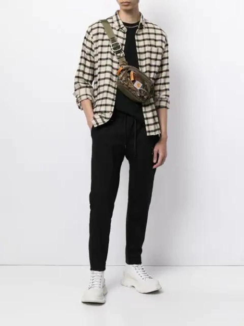 Farfetch's Post | Wearing: Alexander Mcqueen Tread Slick Suede Platform Sneakers In White; Roar D-ring Detail Track Pants In Black; Cmmn Swdn Ridley T In Black