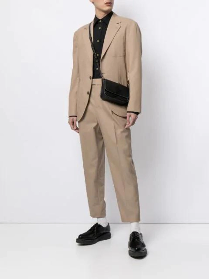 Farfetch's Post | Wearing: Vivienne Westwood Orb Embroidered Two-button Krall Shirt In Black; Brunello Cucinelli Two-piece Tailored Suit In Neutrals; Jw Anderson Black Nano Anchor Leather Cross Body Bag