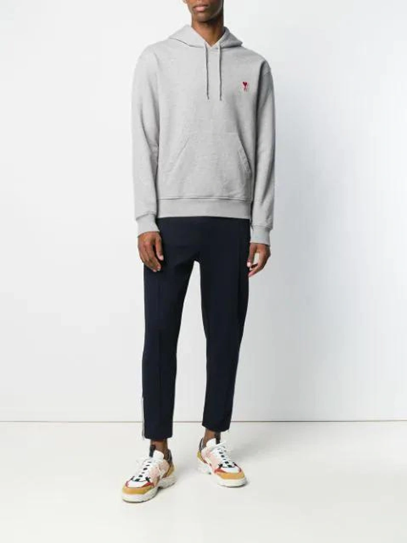 Farfetch's Post | Wearing: Ami Alexandre Mattiussi Hoddie Sweatshirt With Red Ami De Coeur Patch In Grey; Ami Alexandre Mattiussi Trackpants With Ami Heart Patch And Zipped Pockets And Hem In Black