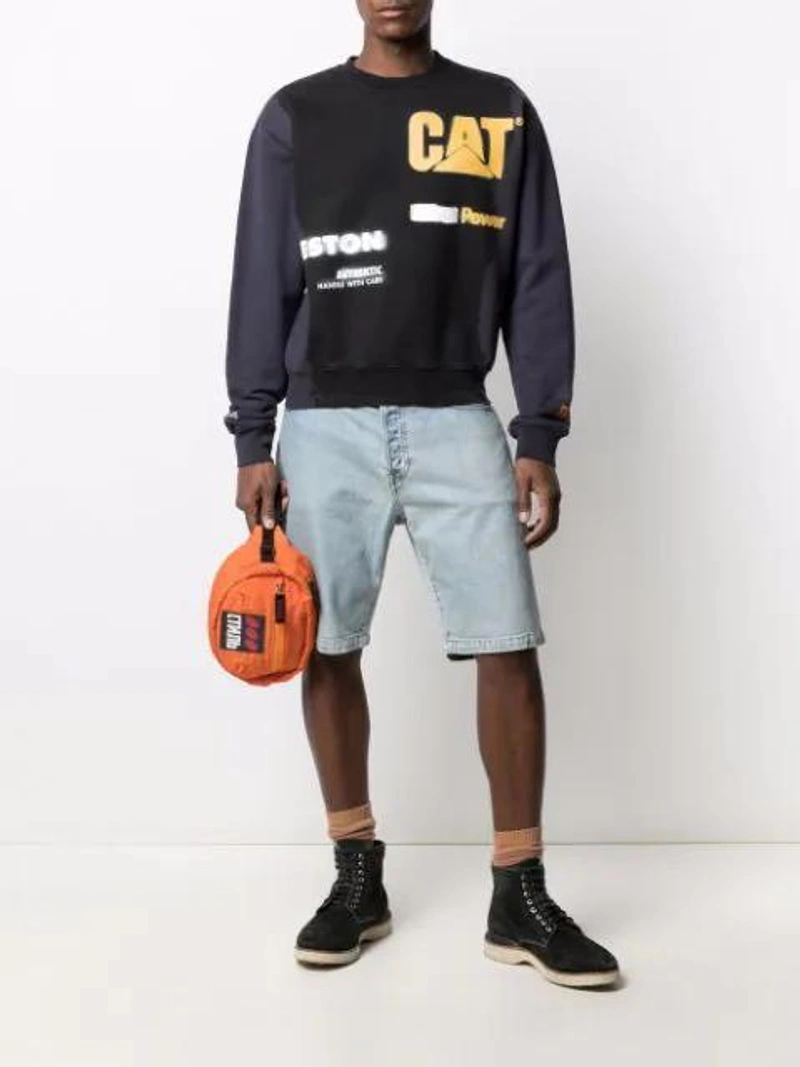 Farfetch's Post | Wearing: Heron Preston X Caterpillar Logo-print Sweatshirt In Black; Wardrobe.nyc X Levi's Release 04 Denim Shorts In Blue; Heron Preston Ctnb Logo Patch Belt Bag In Orange
