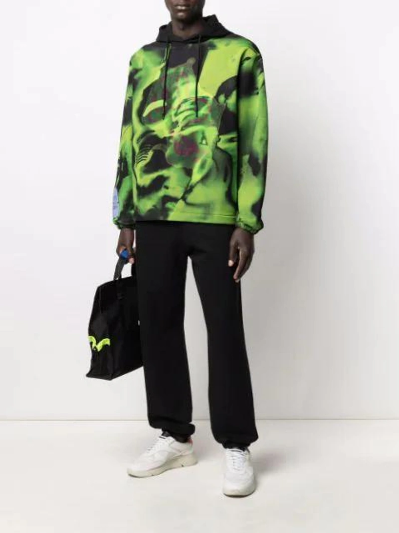 Farfetch's Post | Wearing: Mcq By Alexander Mcqueen Overlay Fluid Digital Print Hoodie In Green; Off-white Diagonal Striped Track Pants In Black; Ader Error Logo Holdall In Black