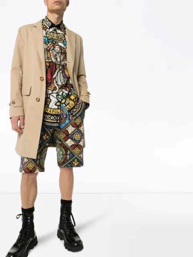 Farfetch's Post | Wearing: Dolce & Gabbana Kings Age Print Bermuda Shorts In Black; Dolce & Gabbana Cotton Martini Shirt With Napoleon Print In Brown; Fendi Belted Trench Coat In Neutrals