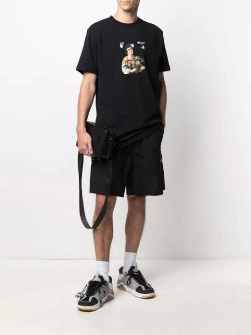 Farfetch's Post | Wearing: Off-white Black Oversized Caravaggio Boy T-shirt; Off-white Arrow Graphic Sports Socks In White; Off-white Men's Binder Clip Leather Camera Bag In Black