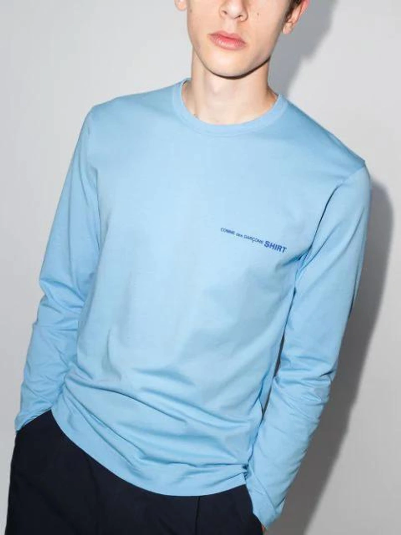 Farfetch's Post | Wearing: Comme Des Garçons Shirt Logo Print Long-sleeve T-shirt In Light Blue; Studio Nicholson Rosario Cotton-poplin Cropped Wide-leg Trousers In Blue; Maison Margiela Striped Cotton Blend Shirt In Grey