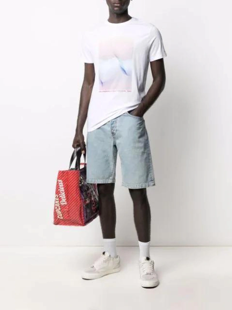 Farfetch's Post | Wearing: Karl Lagerfeld Graphic-print Short-sleeve T-shirt In White; Wardrobe.nyc X Levi's Release 04 Denim Shorts In Blue; Comme Des Garçons Shirt Delicious Logo Tote In Purple