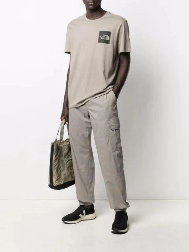 Farfetch's Post | Wearing: The North Face Logo Print T-shirt In Grey; The North Face Straight-leg Cargo Trousers In Grey; Stone Island 'burnout' Shopper In Green