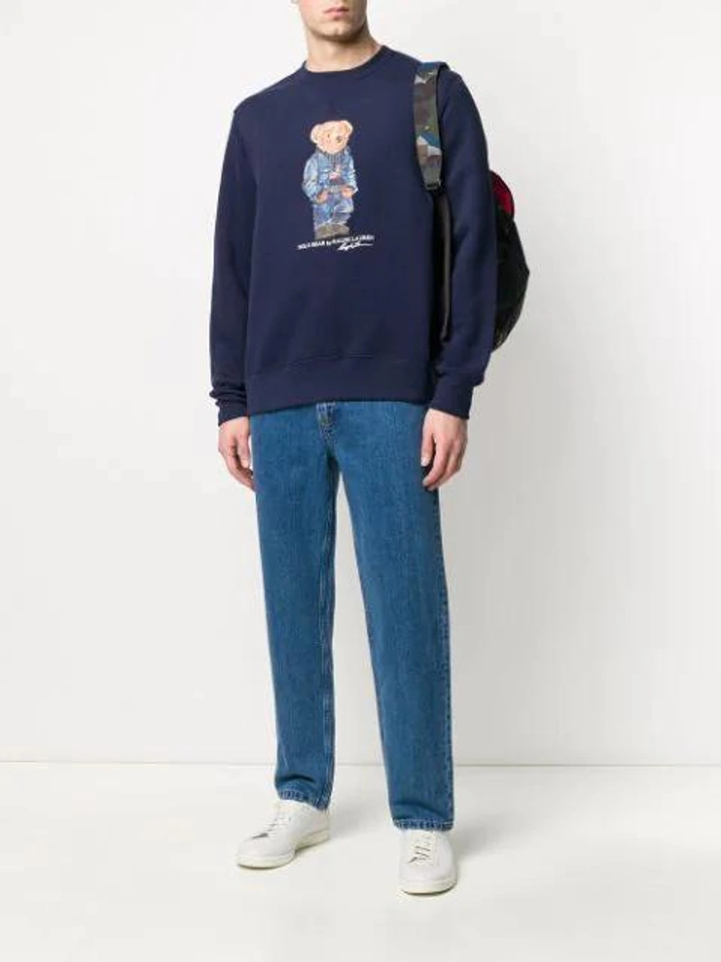 Farfetch's Post | Wearing: Ralph Lauren Bear Print Fleece Sweatshirt In Blue; Apc High-rise Straight Leg Jeans In Blue; Adidas Originals Adidas White And Blue Stan Smith Sneakers In Grey
