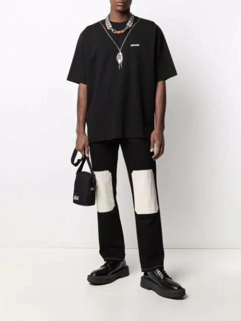 Farfetch's Post | Wearing: Marcelo Burlon County Of Milan Marcelo Burlon Feather Necklace Logo T-shirt In Black; Linder Tube Knee Patch Straight Jeans In Black; Neighborhood Black Logo Patch Cross Body Bag