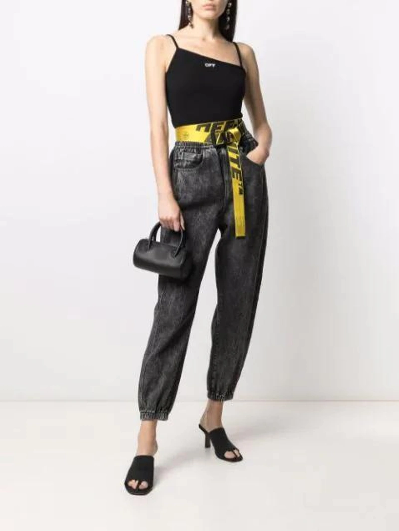 Farfetch's Post | Wearing: Alexander Wang Logo-print Track Pants In Black; Off-white Logo-print Asymmetric-neck Top In Black; Abra Mini Top Handle Tote Bag In Black